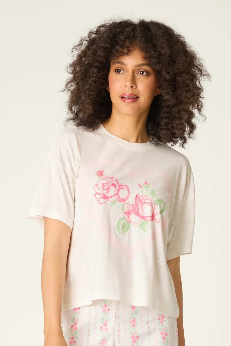 Woman wearing a floral pajama set on a white background