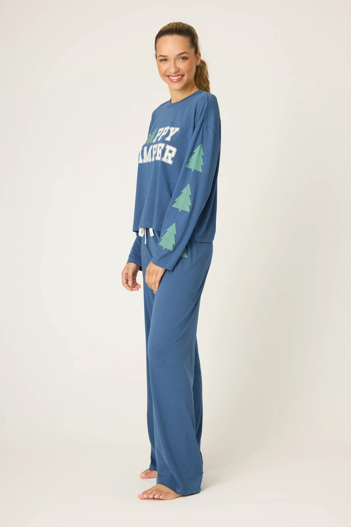 Woman wearing a blue pajama set with tree design on a white background