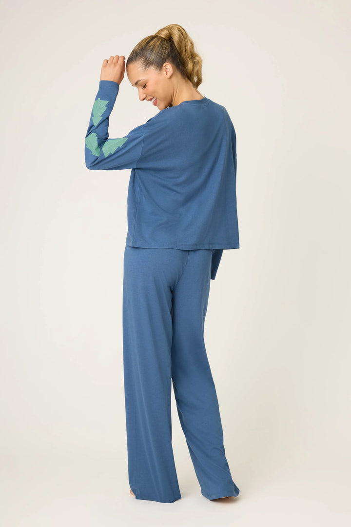 Woman wearing a blue outfit with green sleeves on a white background