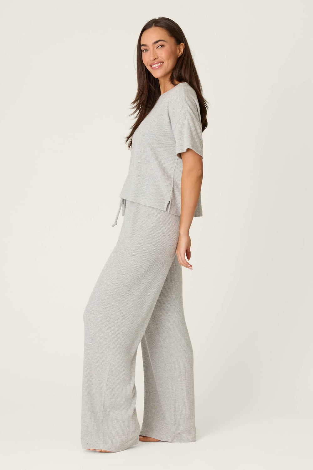 Woman wearing a gray lounge set on a white background