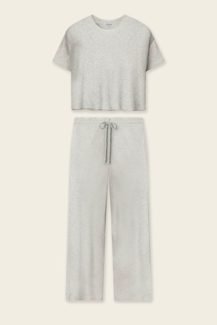 A light heather gray two-piece loungewear set consisting of a short-sleeve cropped t-shirt and matching wide-leg drawstring pants, laid flat against a light cream background.