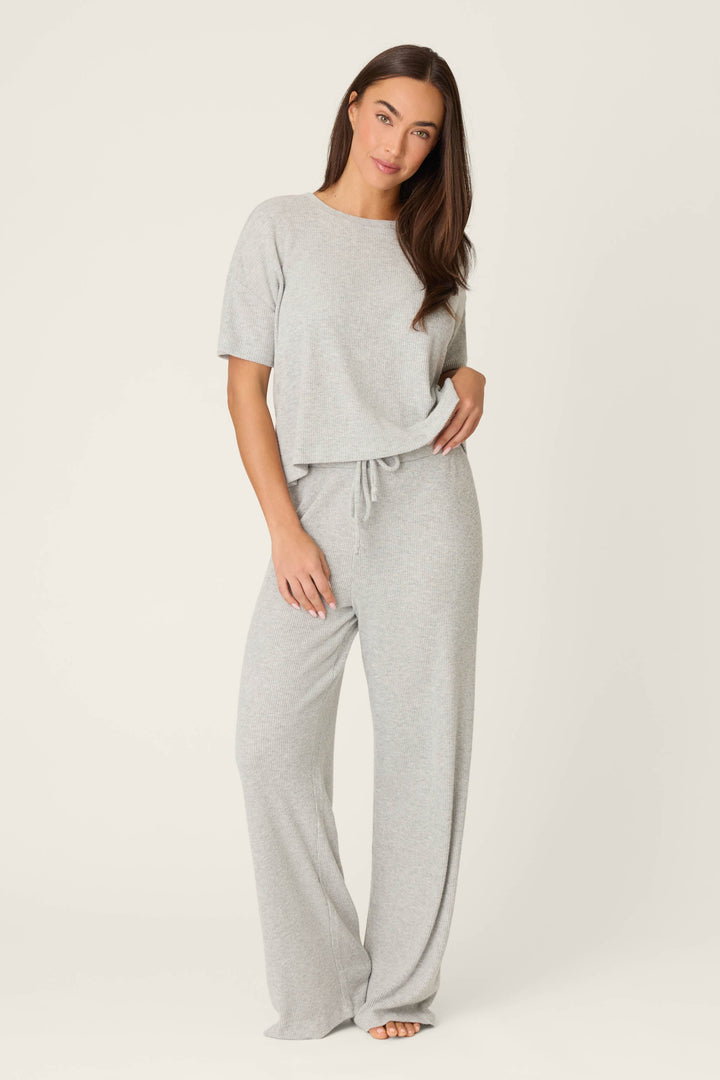 Woman wearing a gray pajama set on a white background