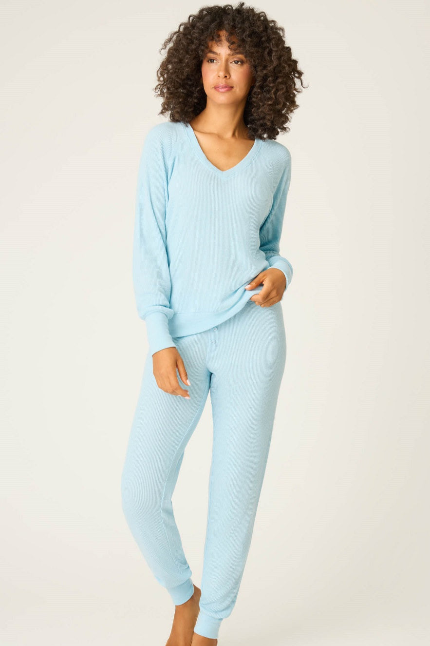 Woman wearing light blue pajamas on a white background