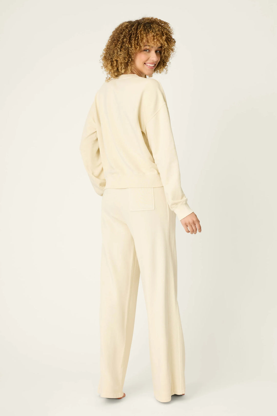 Woman wearing a cream-colored outfit on a white background