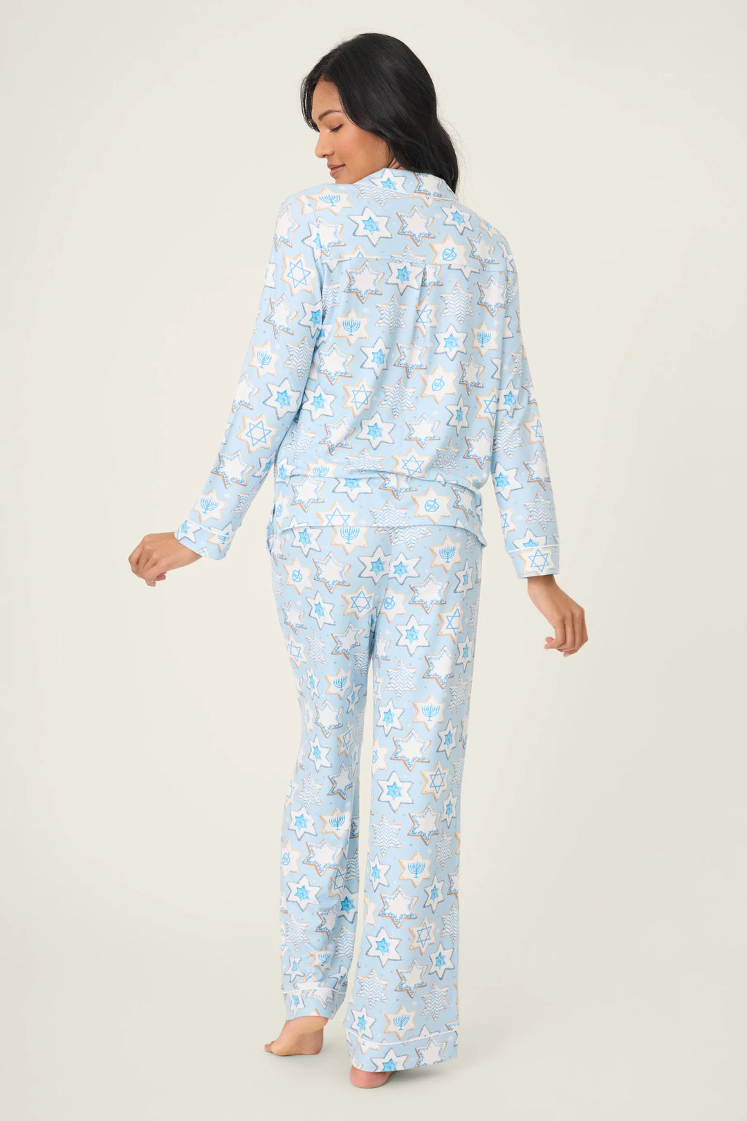 Woman wearing a light blue cookie print pajama set on a beige background