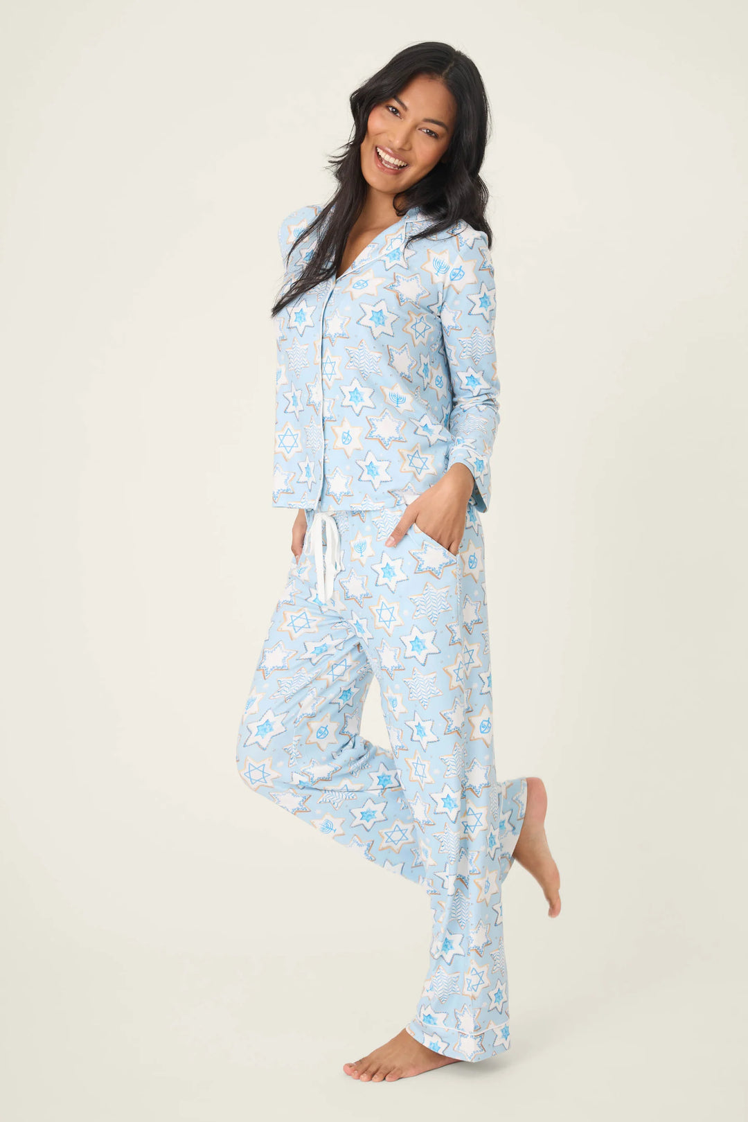 Woman wearing a light blue cookie print pajama set on a white background