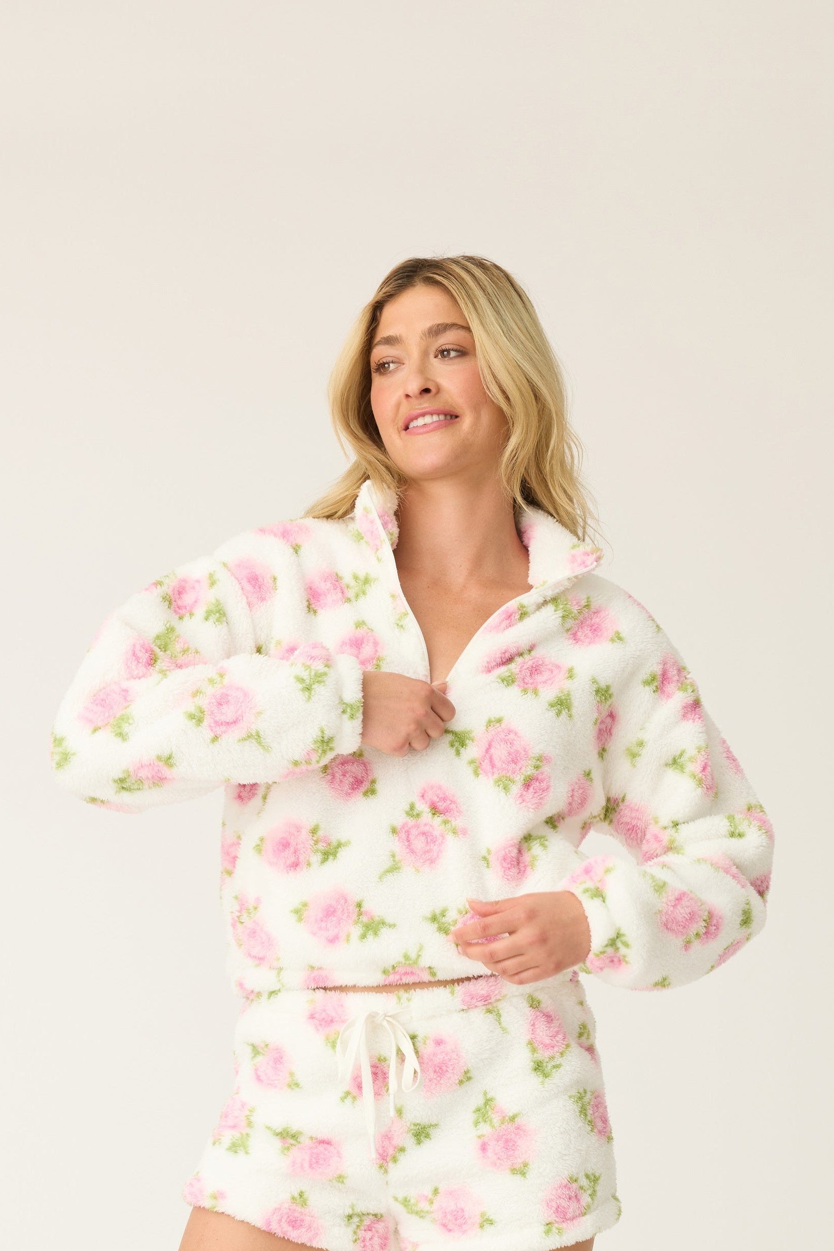 Woman wearing a floral pajama set on a white background