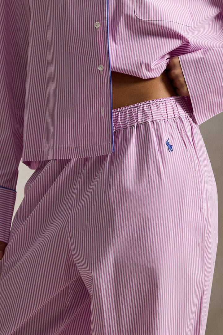 Person wearing a pink and white striped pajama set with a visible polo ralph lauren brand logo.