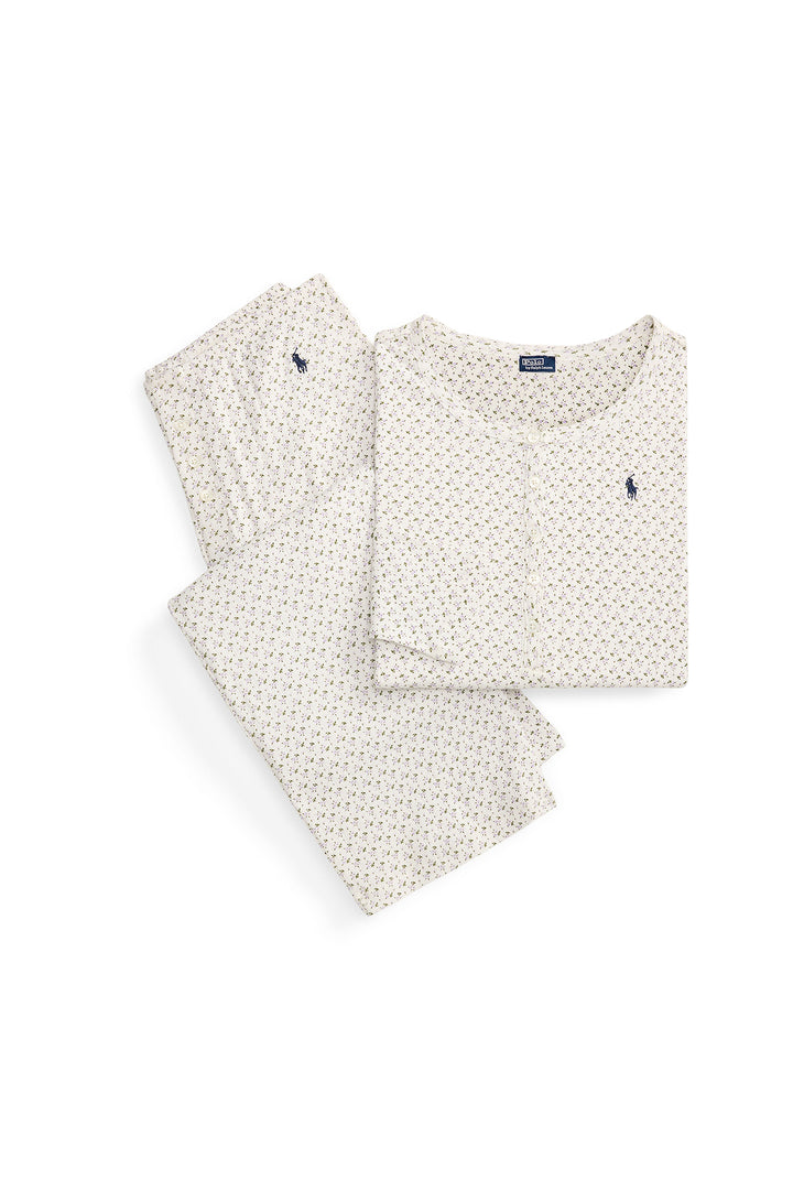 Set of folded pajama pants and shirt with a small floral pattern on a white background