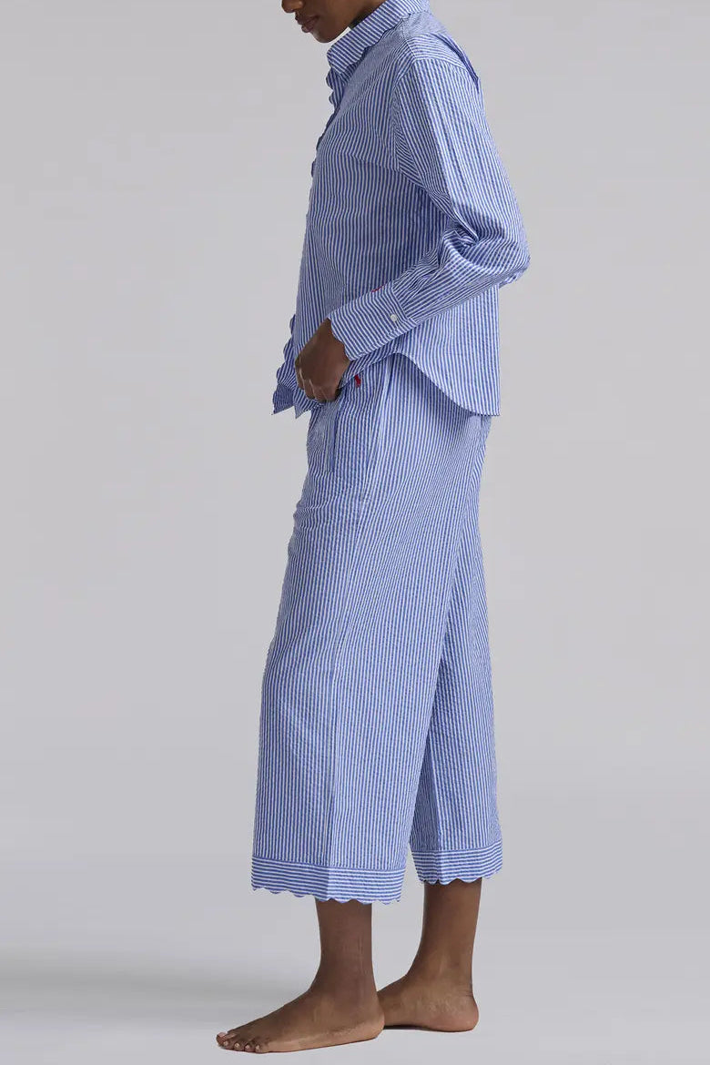 Person wearing a blue checkered outfit with a long skirt on a plain background