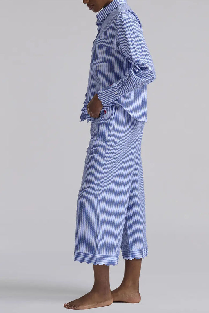Person wearing a blue checkered outfit with a long skirt on a plain background