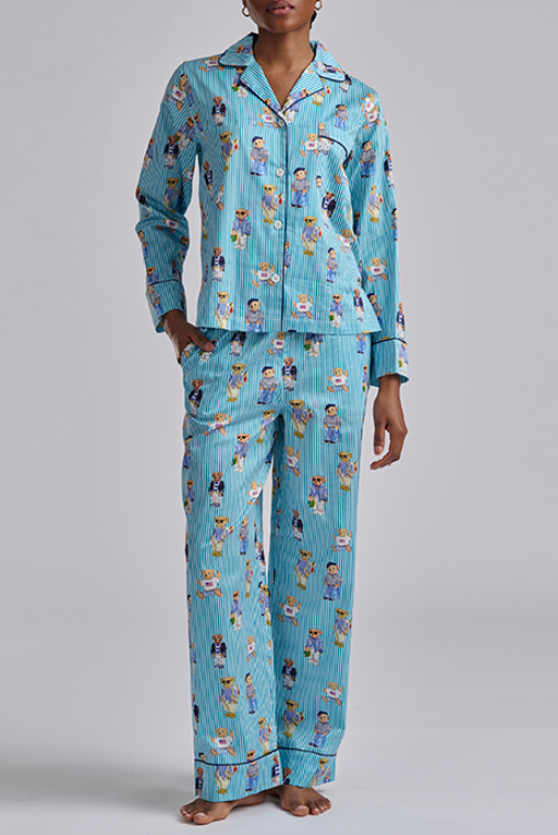 Person wearing a blue polo ralph lauren pajama set with teddy bear print on a gray background. Comfy cotton set with  popular bear print.