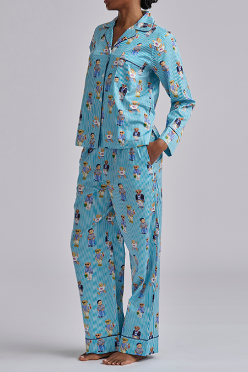 Person wearing a blue polo ralph lauren pajama set with teddy bear print on a gray background. Comfy cotton set with  popular bear print.
