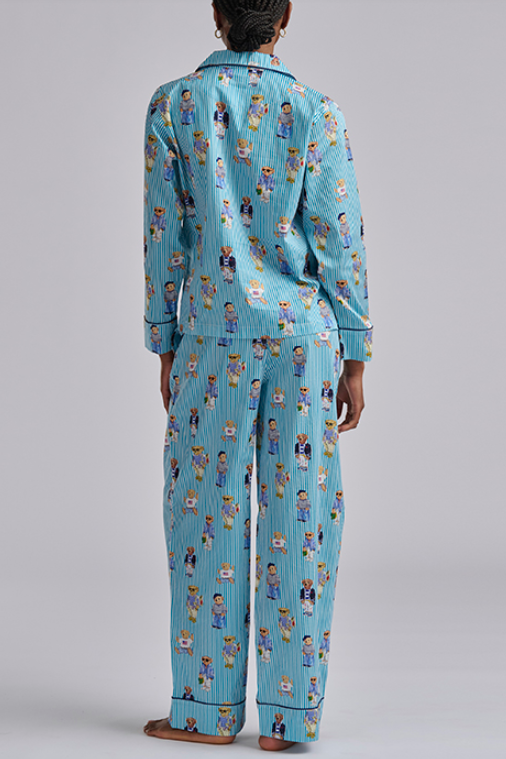 Person wearing a blue polo ralph lauren striped pajama set with teddy bear print on a gray background. Comfy cotton set with  popular bear print.