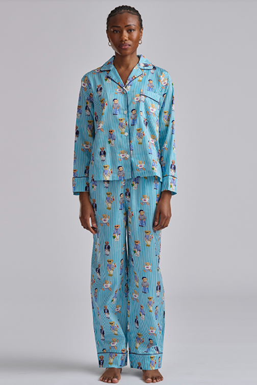 Person wearing a blue polo ralph lauren pajama set with teddy bear print on a gray background. Comfy cotton set with  popular bear print.