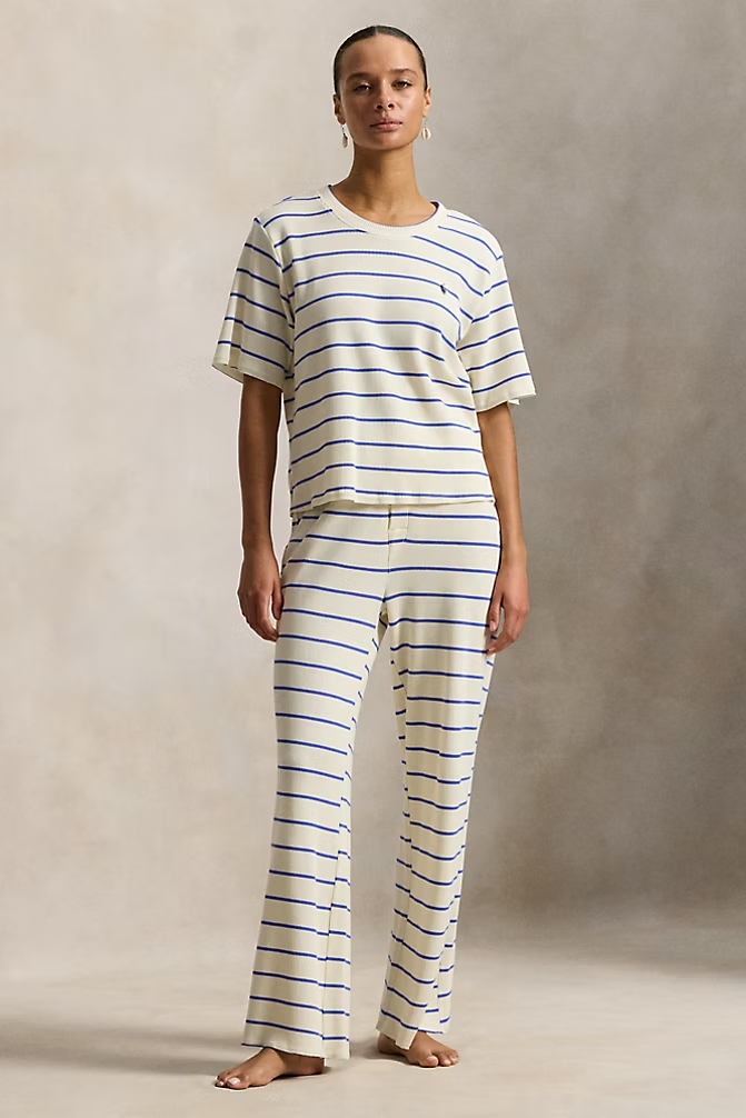 Person wearing a Polo Ralph Lauren waffle texture white and blue striped pajama set against a neutral background