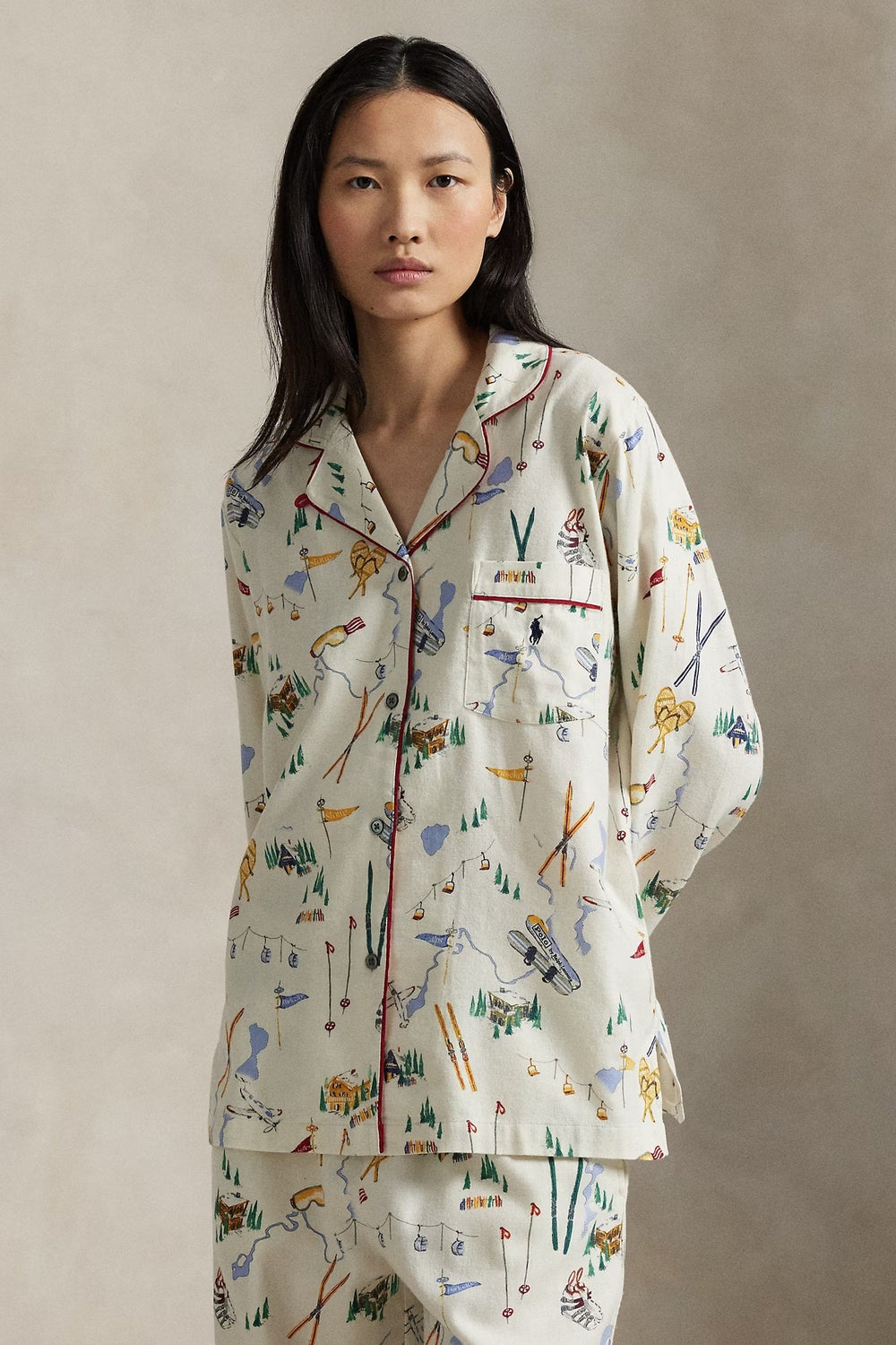 Woman wearing a patterned ski pajama set against a plain background