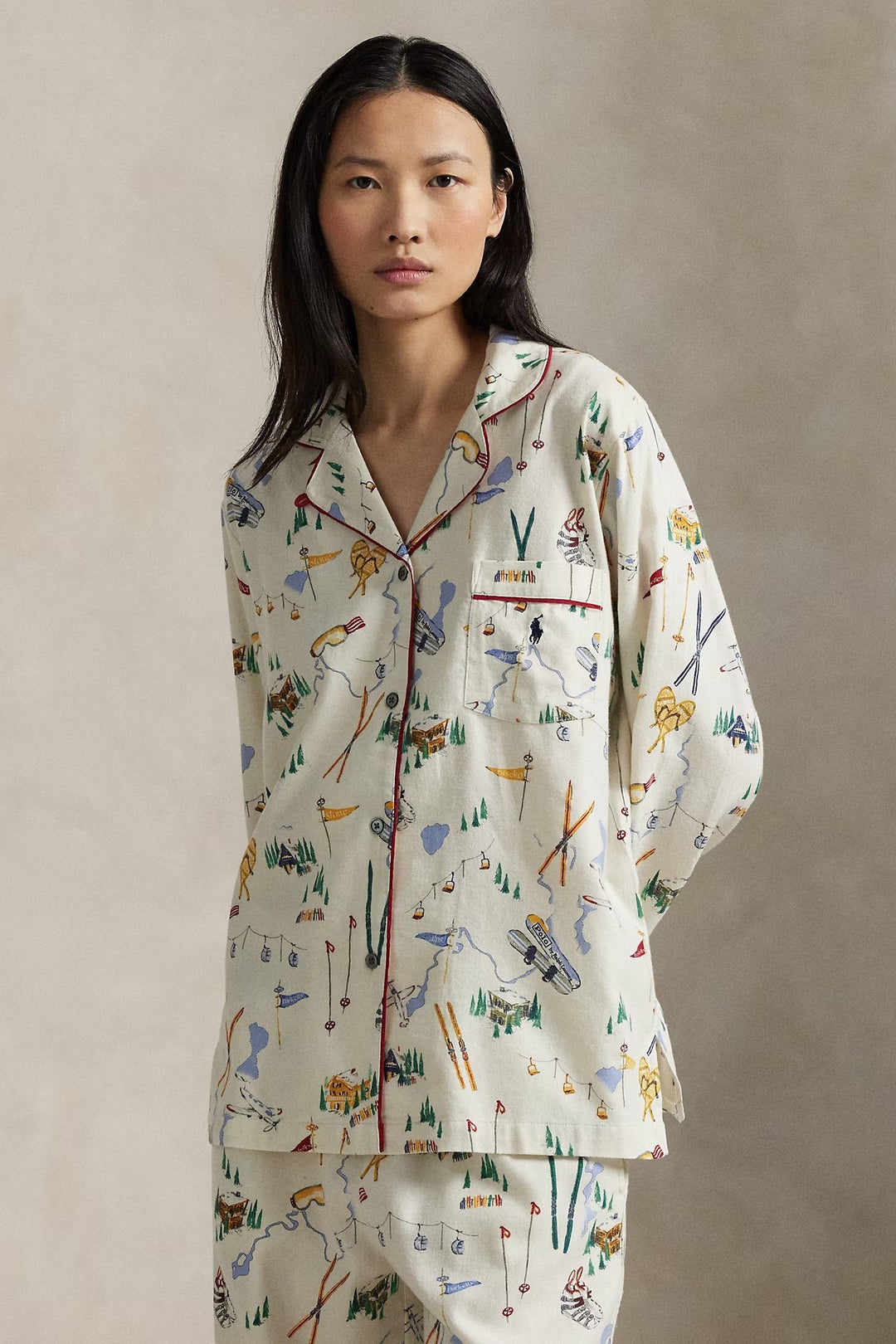 Woman wearing a patterned ski pajama set against a plain background