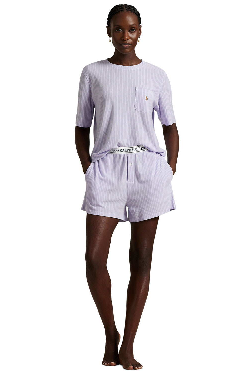 Woman wearing a light purple pajama set with a visible brand logo on a white background