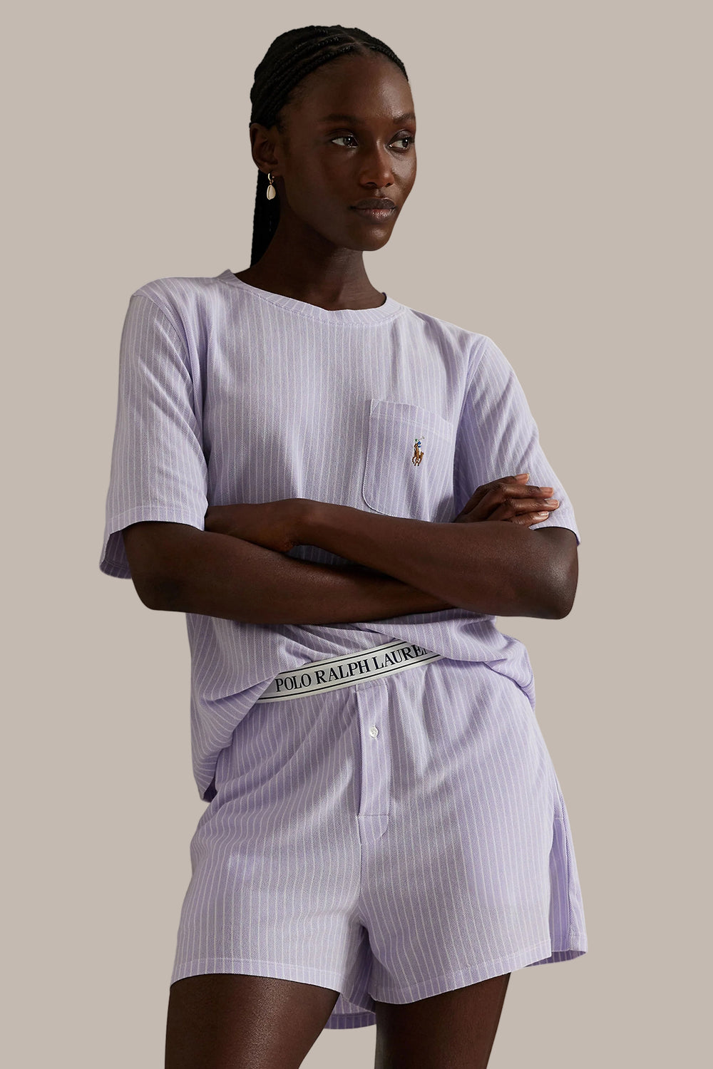 Woman wearing a striped outfit with Ralph Lauren logo on a plain background