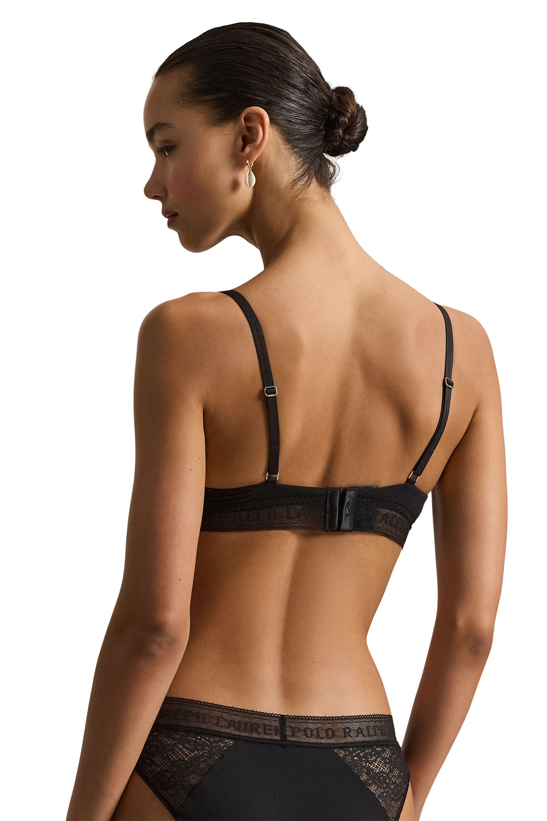 Woman wearing a black bra and underwear set on a white background