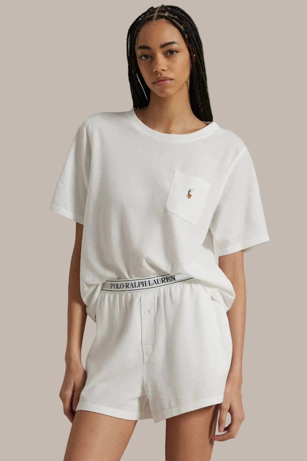 Person wearing a white t-shirt and shorts with Ralph Lauren logo on a plain background