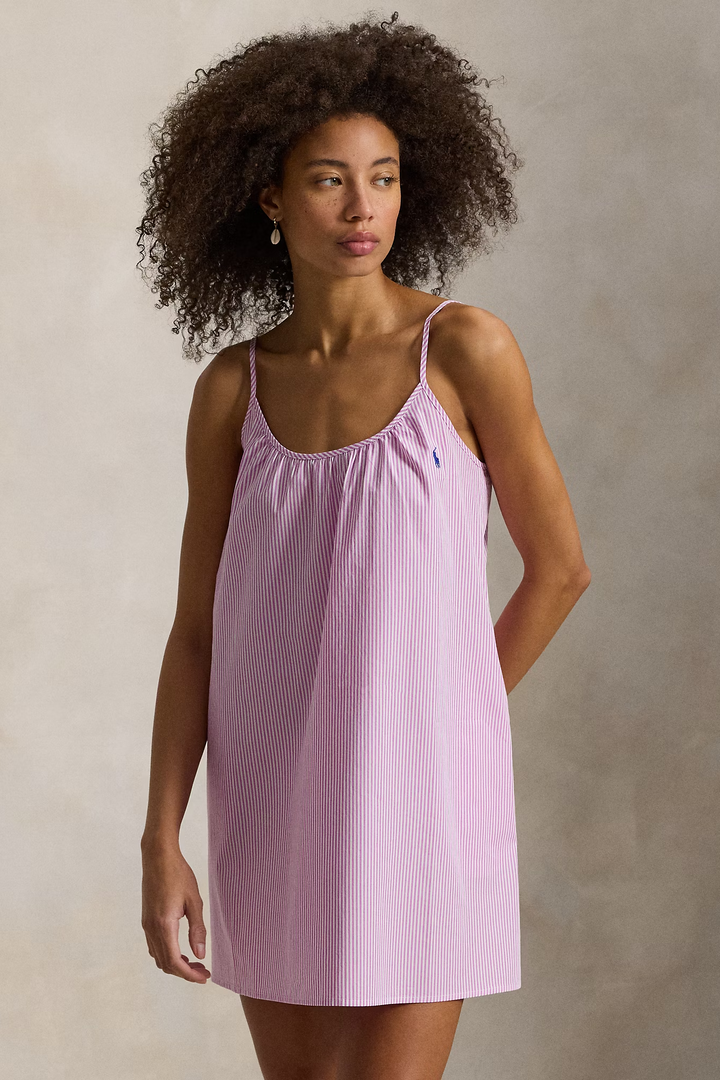 Woman wearing a pink striped nightgown against a neutral background