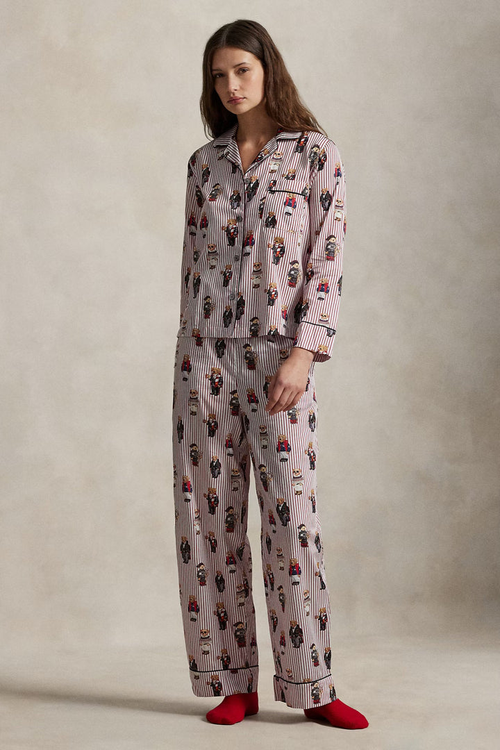 Woman wearing a patterned pajama set with red socks on a neutral background