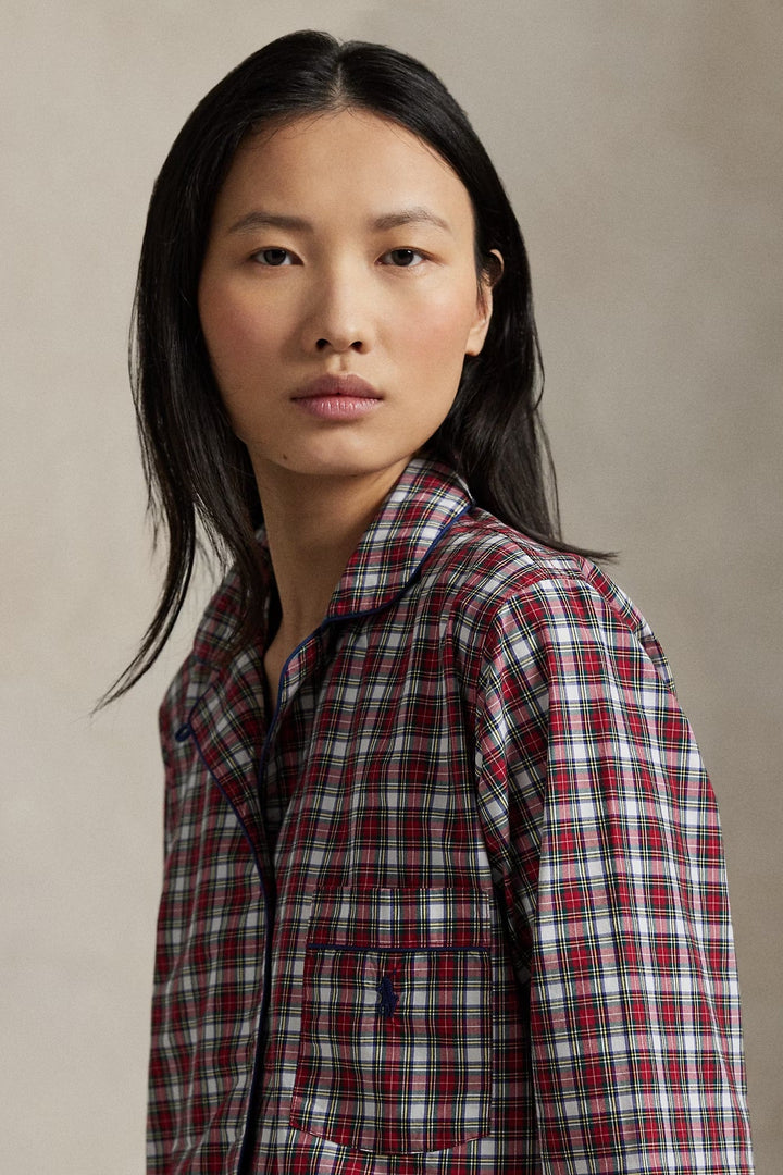 Woman wearing a red and white plaid shirt against a beige background