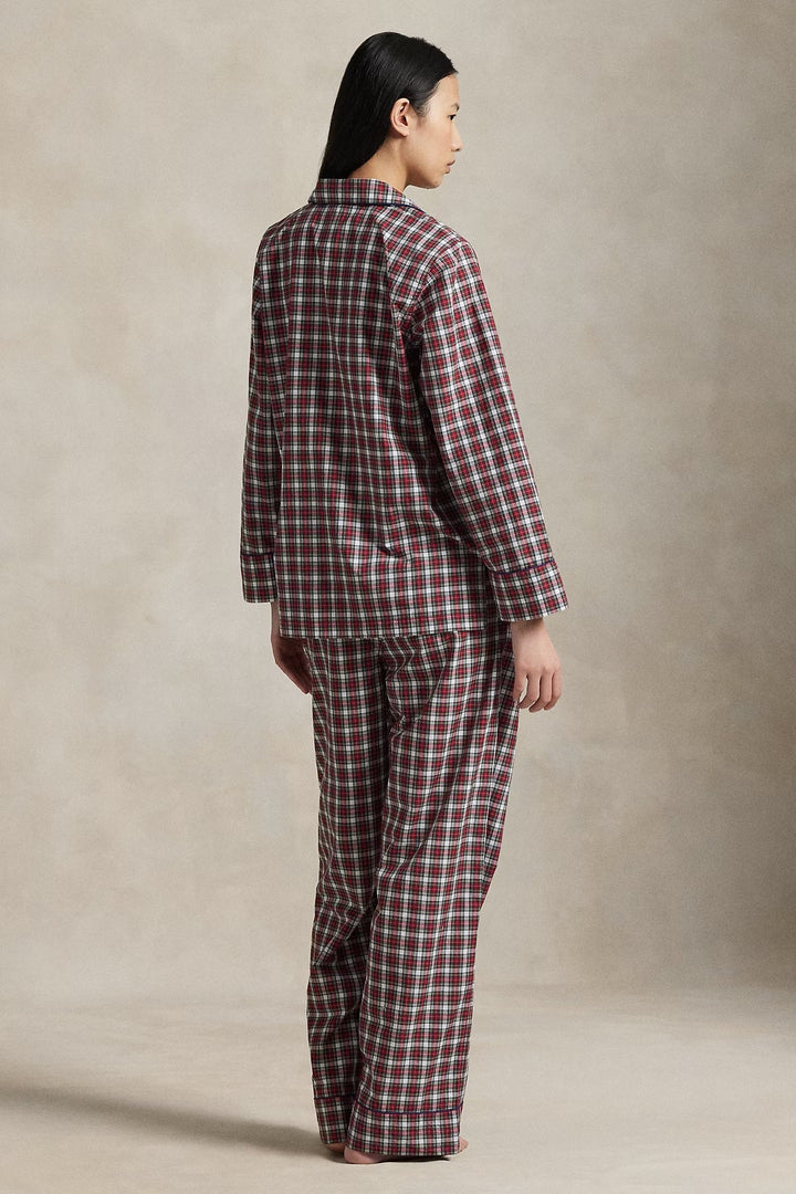 Person wearing a red and white checkered pajama set against a beige background