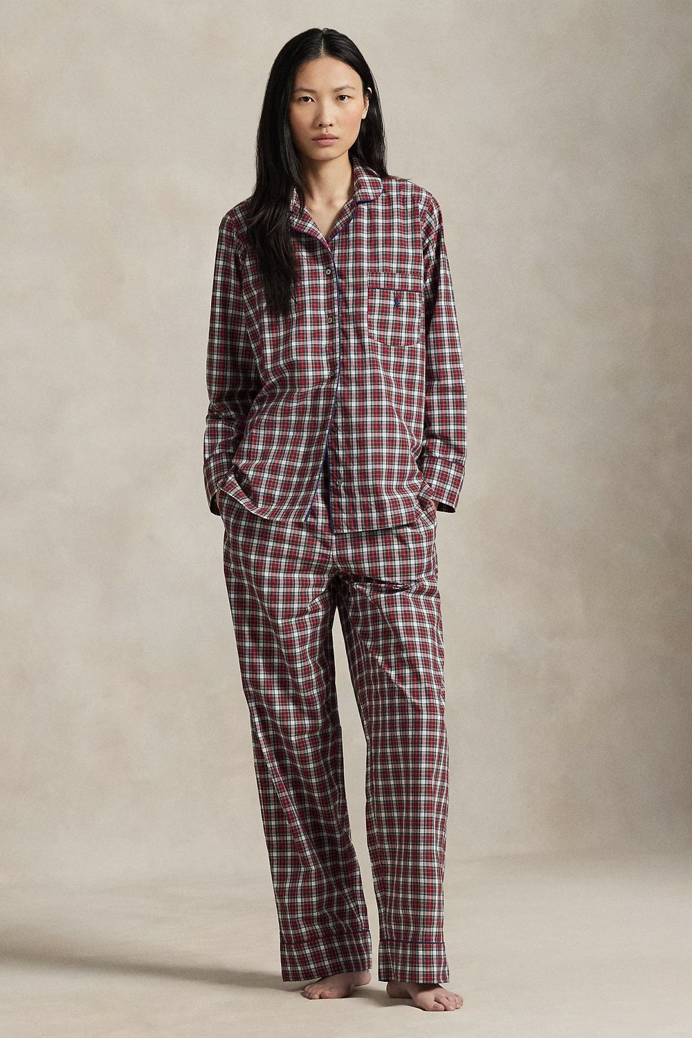 Person wearing a red and white checkered pajama set against a neutral background