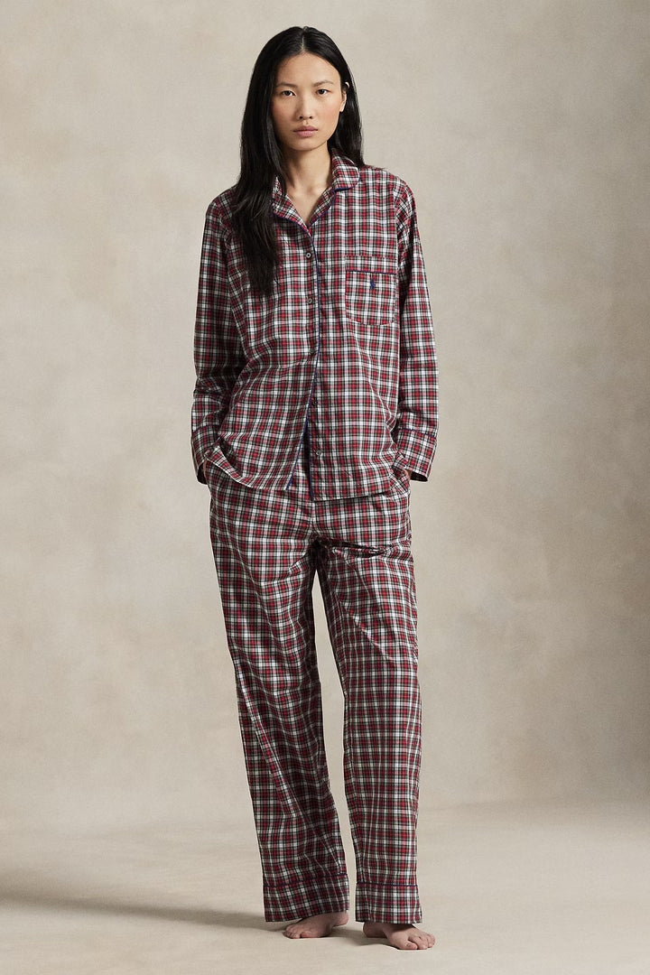 Person wearing a red and white checkered pajama set against a neutral background