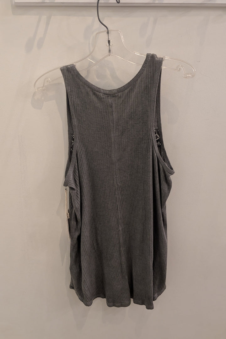 Gray sleeveless top on a hanger against a plain background
