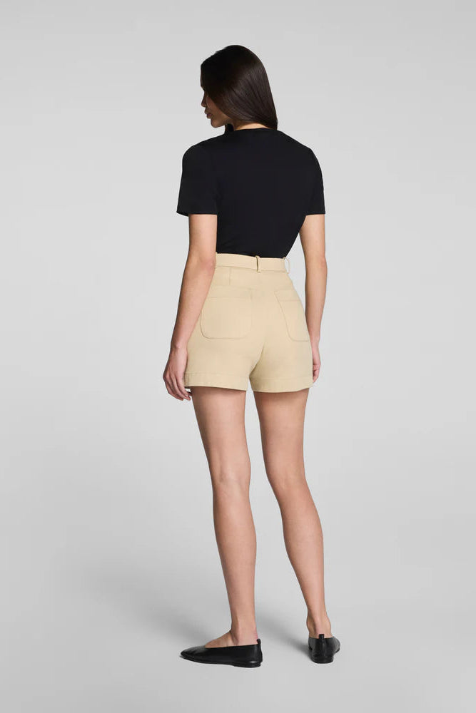 Person wearing a black top and beige shorts on a gray background