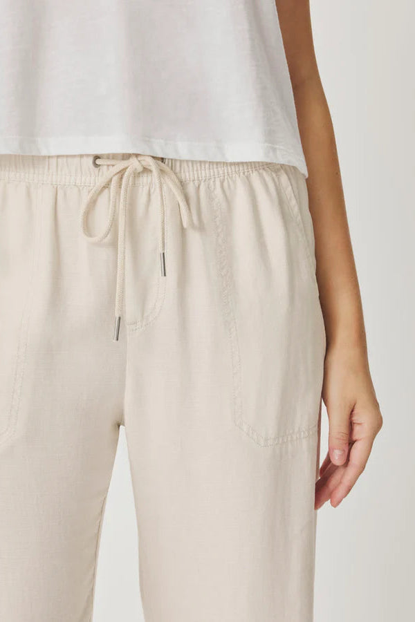 Beige pants with a drawstring on a plain background