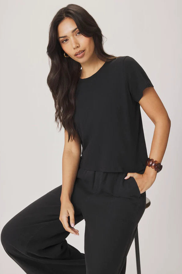 Woman wearing a black outfit against a plain background