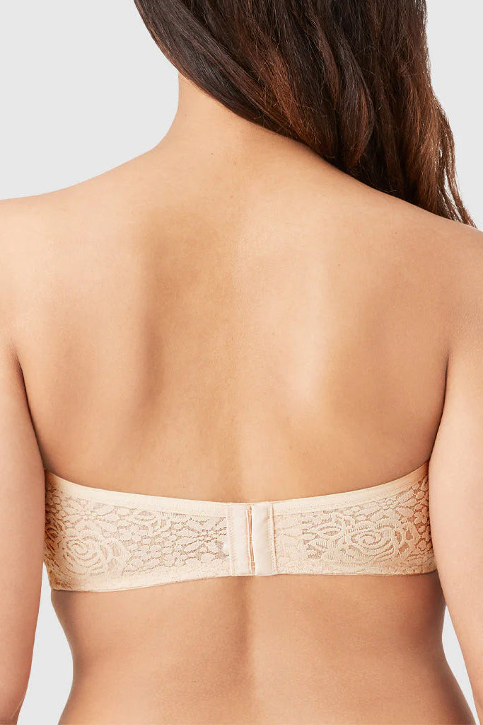 Beige strapless bra worn by a model on a plain background